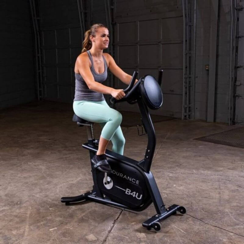 Body-Solid Endurance Upright Bike B4UB - side view photo of a woman using the equipment