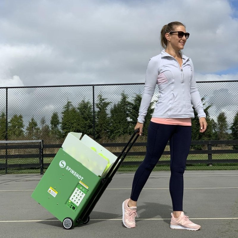 Spinshot Player Tennis Ball Machine - woman wheeling in a green box